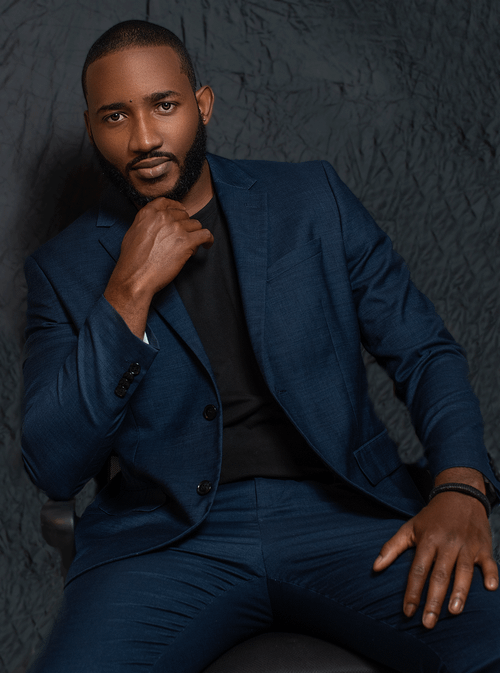 Free Elegant portrait of a man posing confidently in a blue suit against a gray background. Stock Photo