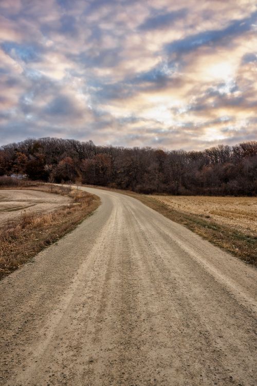 Free Picturesque dirt road in Elgin, MN with a vibrant sky and autumn forest backdrop. Stock Photo