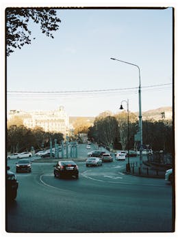 A busy roundabout in Tbilisi, Georgia, showcasing urban life and cityscape.