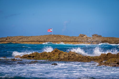 Porto Rican Flag on Rocks on Sea Shore