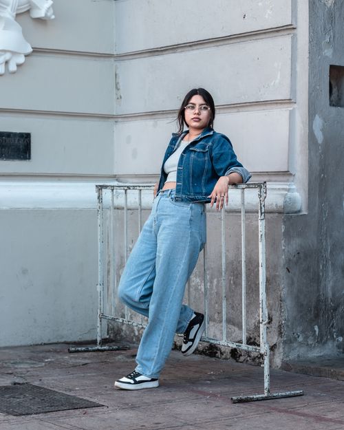 Free Stylish young woman in denim outfit poses against urban backdrop, exuding confidence and modern fashion vibes. Stock Photo