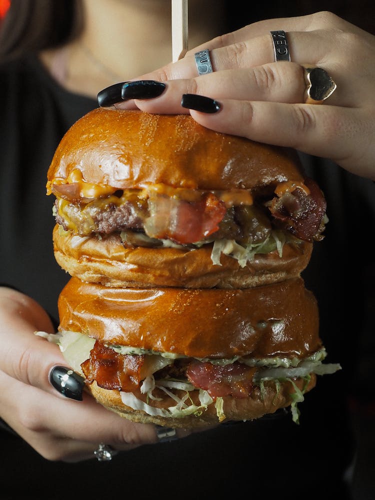 Woman Hands Holding Cheeseburgers