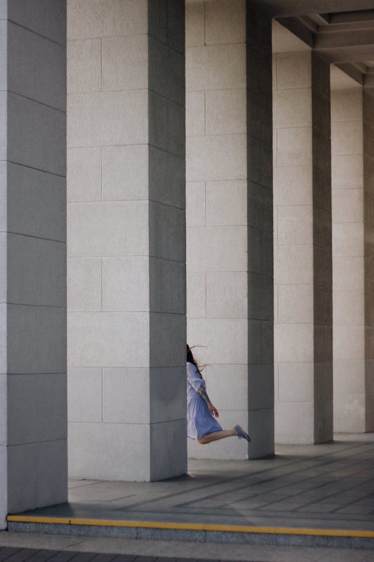 Photo Of A Person Running Around Columns