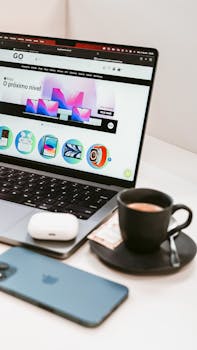 A stylish workspace featuring a laptop, smartphone, and coffee cup, embodying a modern tech lifestyle.