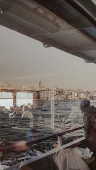 A ferry ride showcasing Istanbul with reflections of Galata Tower and passengers.