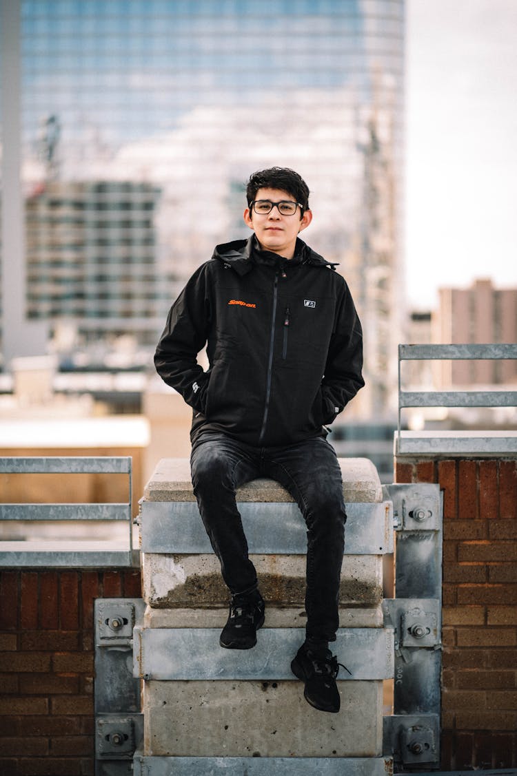 Young Man Sitting On A Terrace Of A Skyscraper 