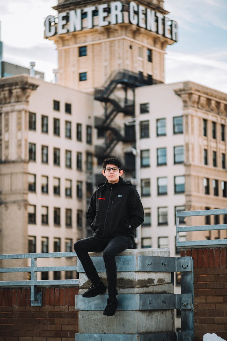 Young Man Sitting On A Terrace Of A Skyscraper 