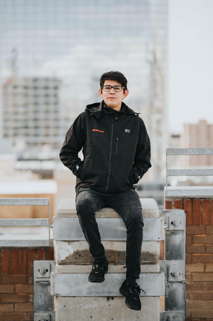 Young Man Sitting On A Terrace Of A Skyscraper 