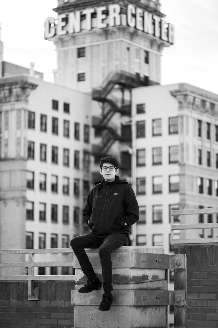 Young Man Sitting On A Terrace Of A Skyscraper 