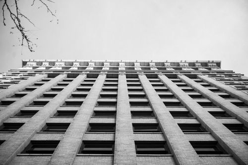 Free Monochrome view of a tall building from below against the clear sky. Stock Photo