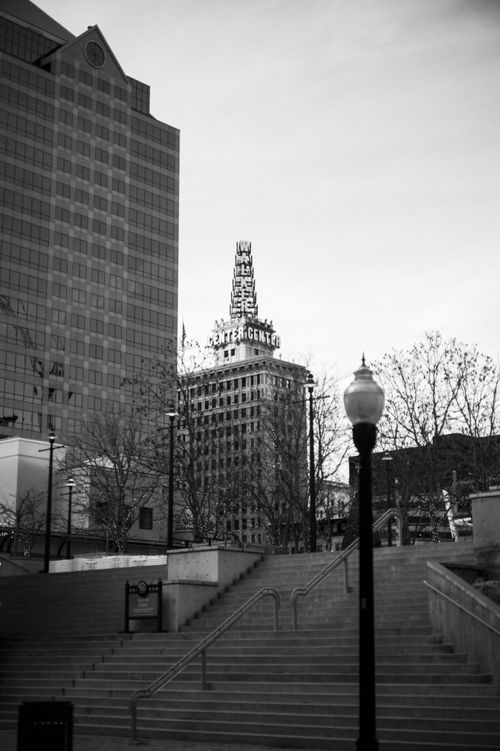 Free Black and white cityscape featuring a historic building with a prominent sign, showcasing urban life. Stock Photo
