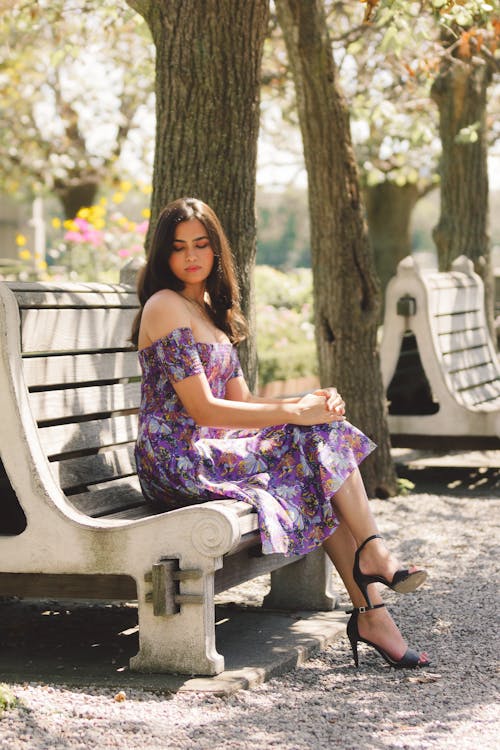 Woman Wearing Floral Dress Sitting on a Bench