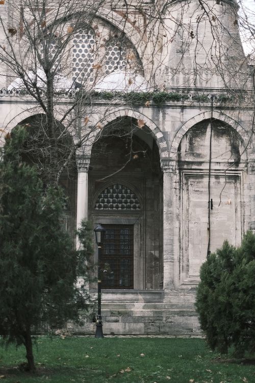Free Beautiful exterior of a historic mosque with arches and a serene garden view. Stock Photo