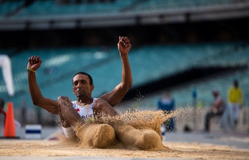Athlete leaping into a sand pit — long jump technique