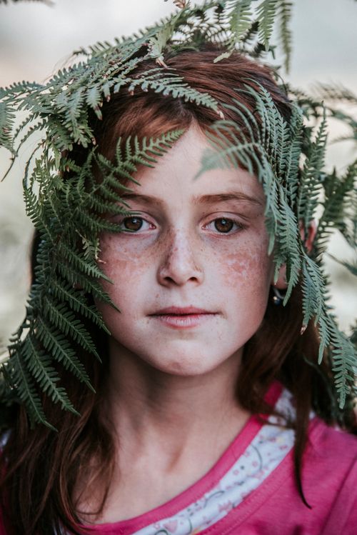 Free Portrait of a freckled girl with ferns in Ismailli, showcasing nature and innocence. Stock Photo