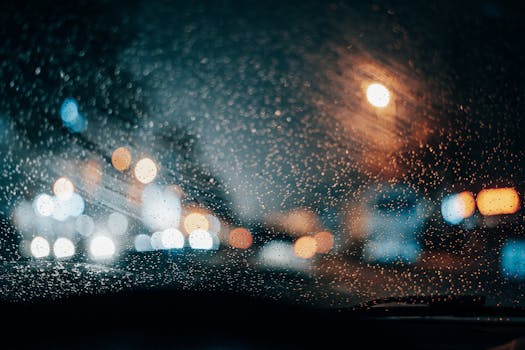 Beautiful view of city lights through a rainy car window, creating a blurred effect at night.
