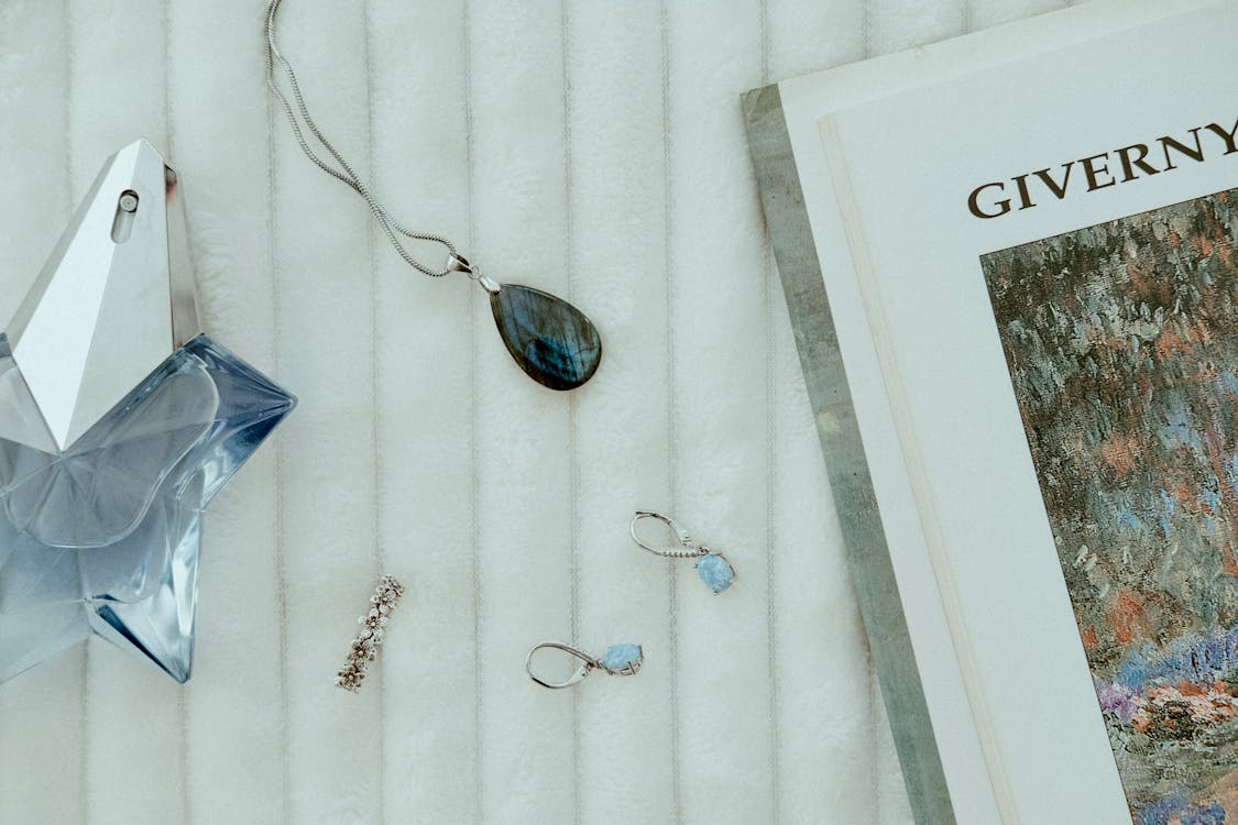 Photograph of a Necklace near a Perfume Bottle