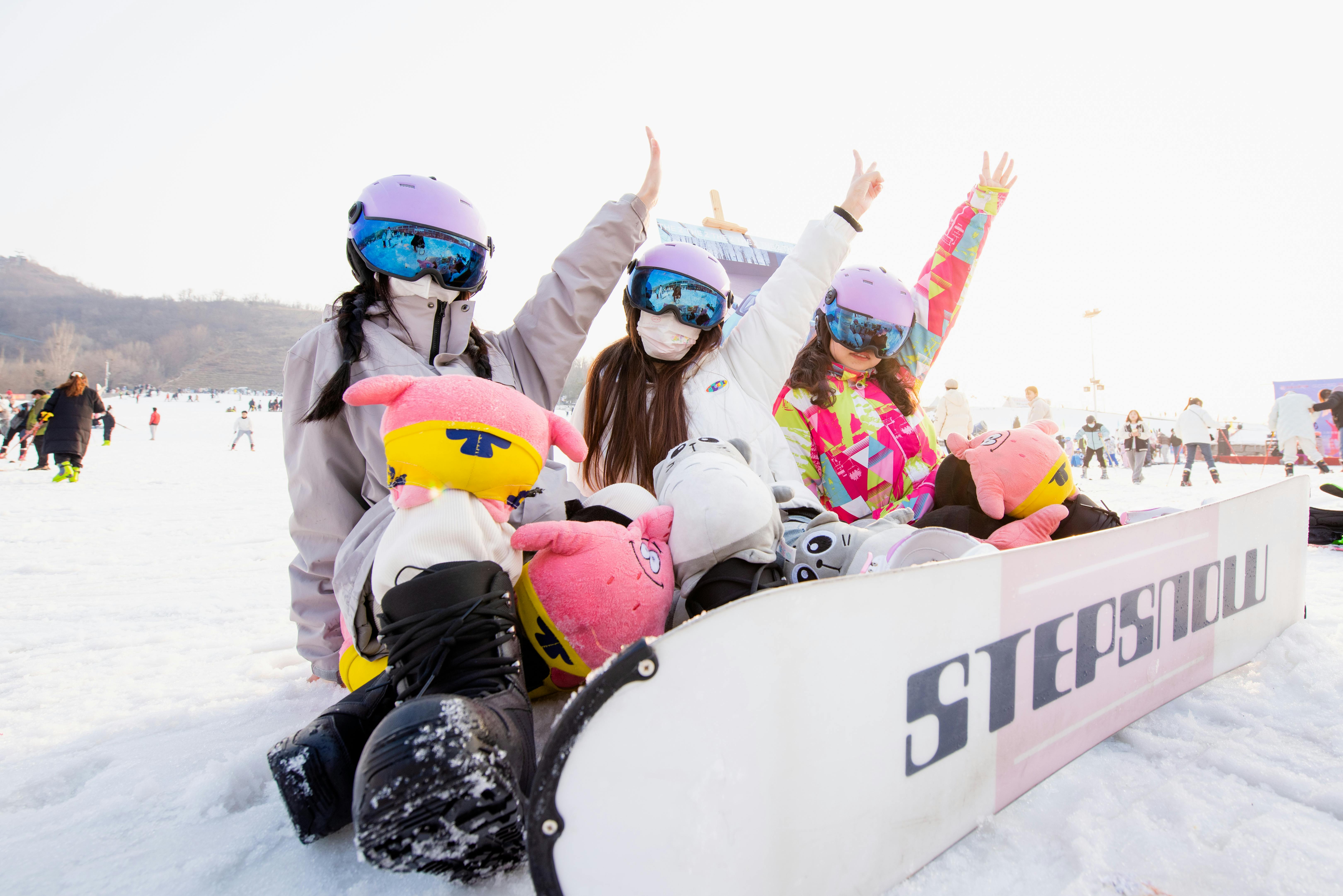 Group of teenage snowboarders enjoying a lively winter day at the ski resort.