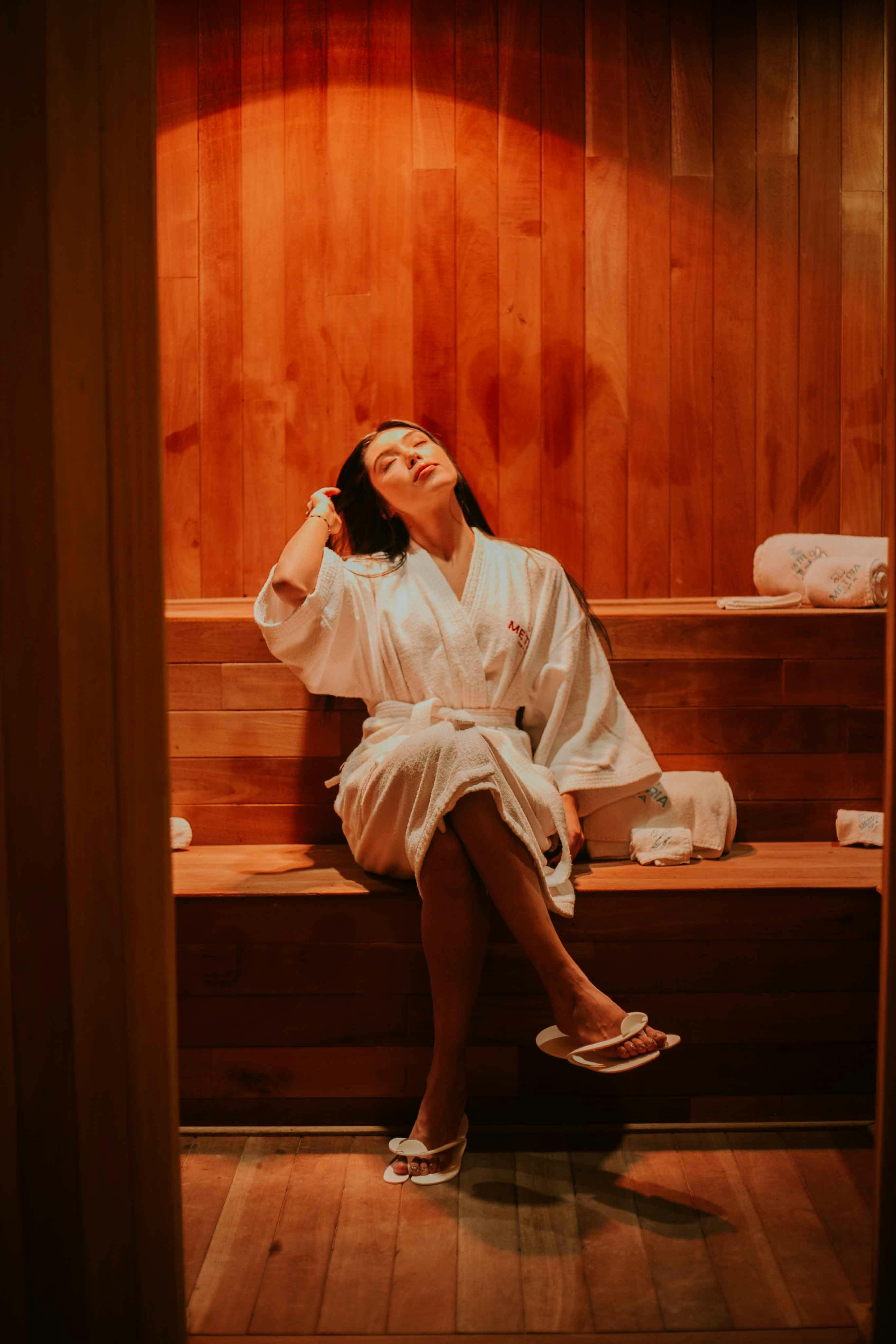 Mujer joven relajándose en la sauna de infrarrojos durante un procedimiento  en el centro del balneario. cuidado del cuerpo