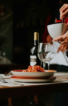 A sophisticated Italian dining scene featuring spaghetti and wine, perfect for a cozy evening out.