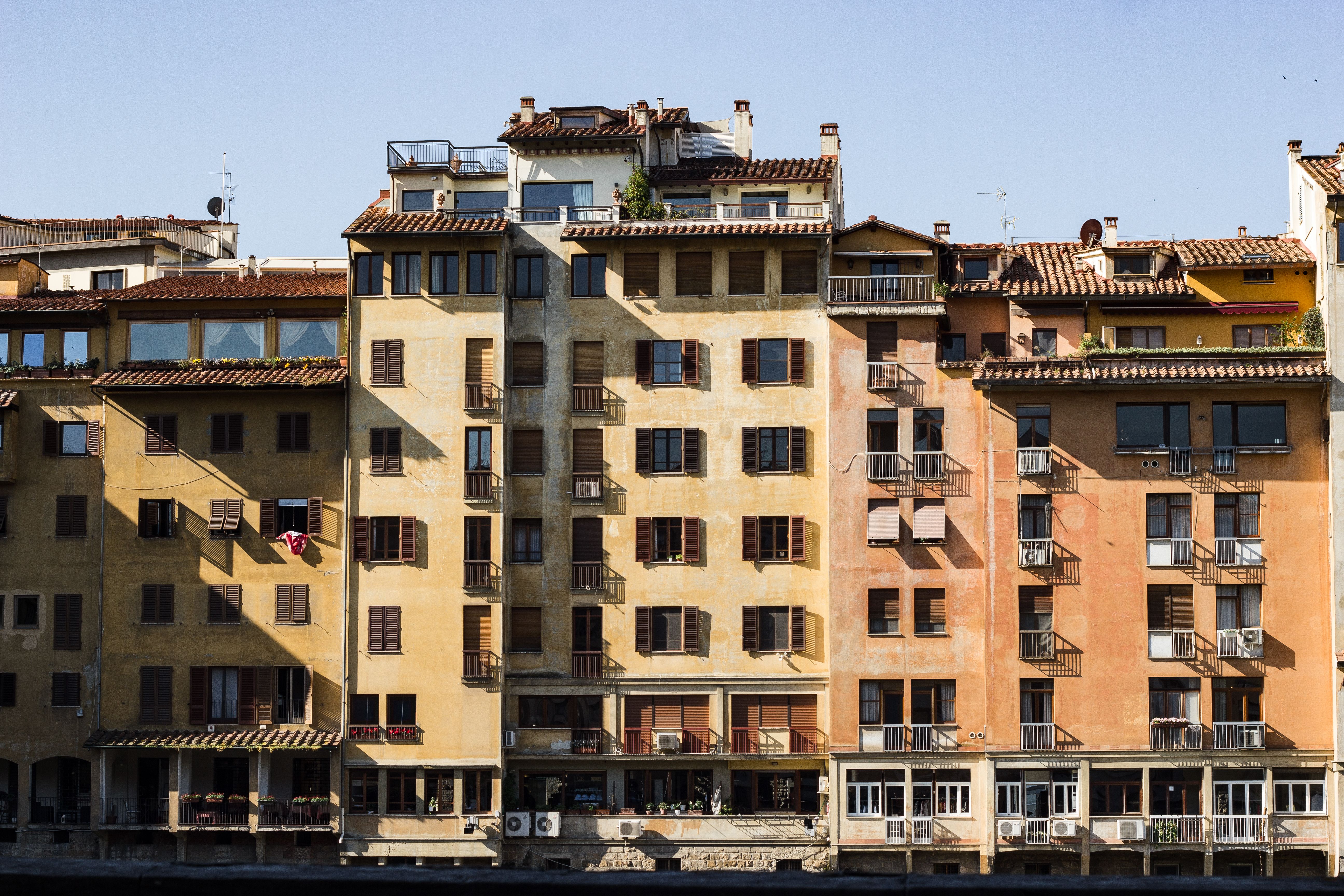 Iconic Florentine architecture with colorful building facades along Arno River in Tuscany, Italy.