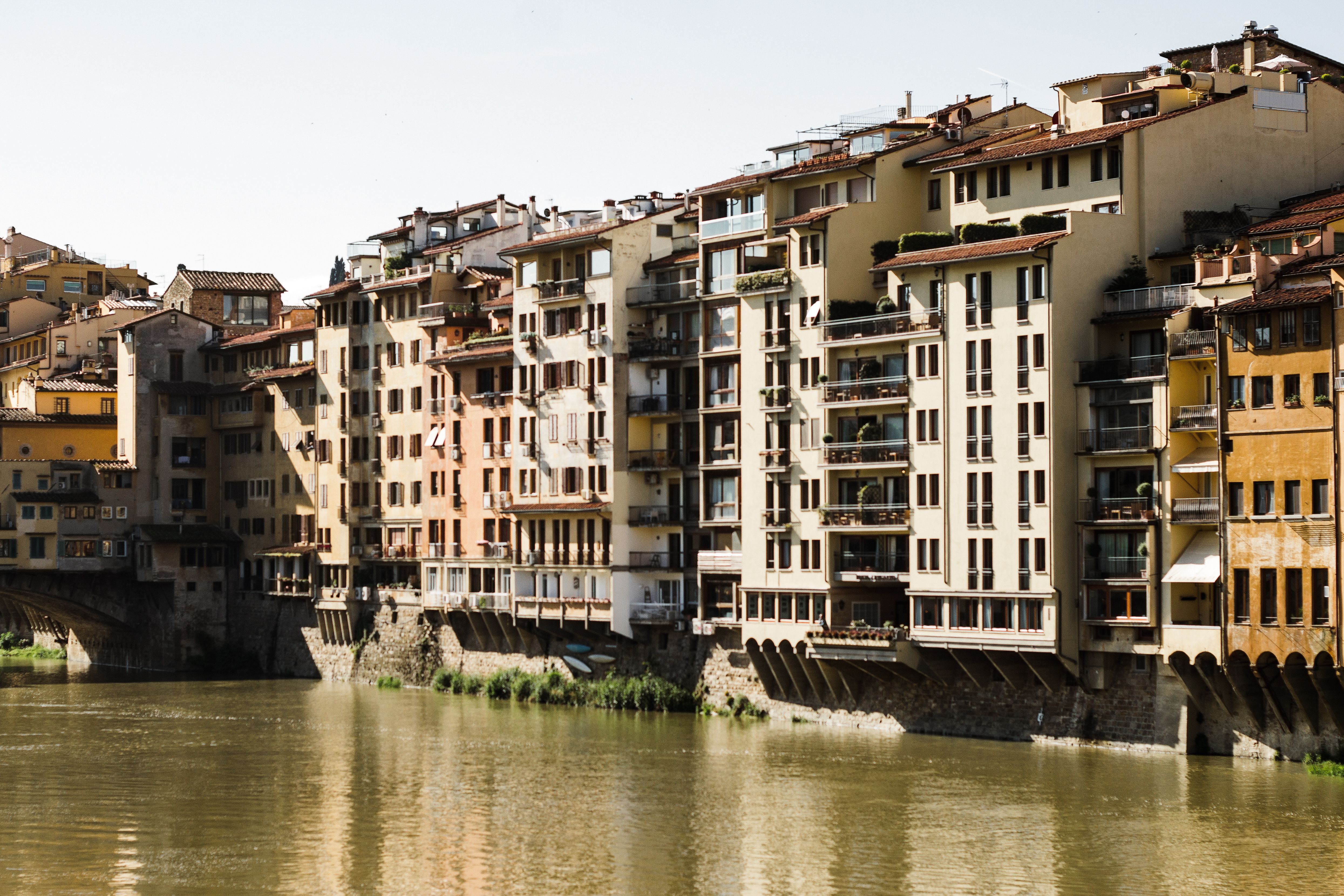 Charming view of historic buildings lining the Arno River in Florence, Italy.
