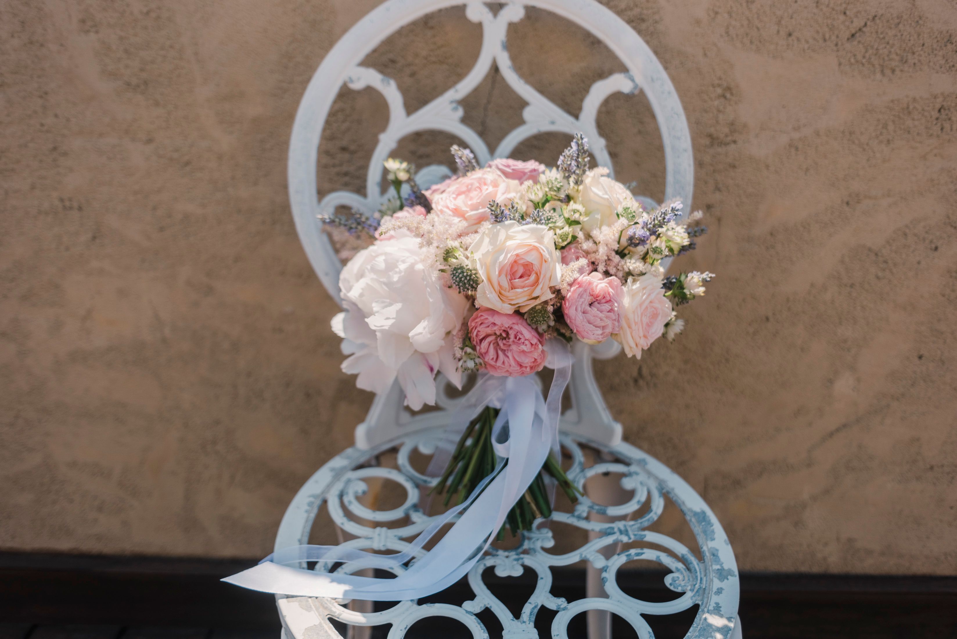 Delicate bouquet of blooming roses on a vintage metal chair, perfect for romantic settings.