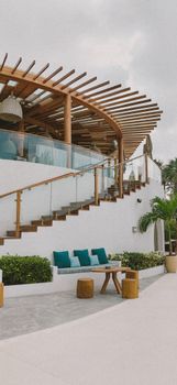 Stylish modern villa featuring a spiral wooden staircase and outdoor seating area.
