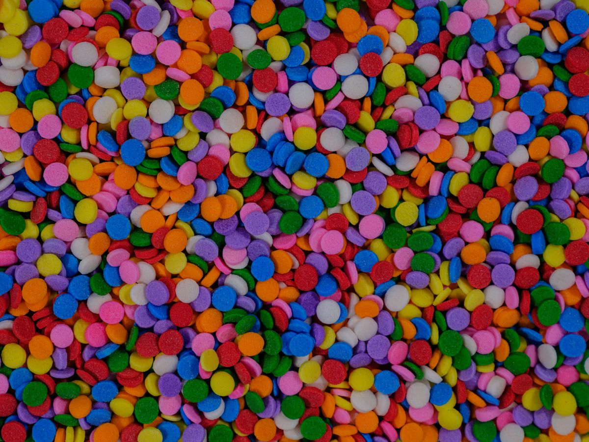 A top view of colorful candy sprinkles in a variety of vibrant hues, perfect for food decoration.