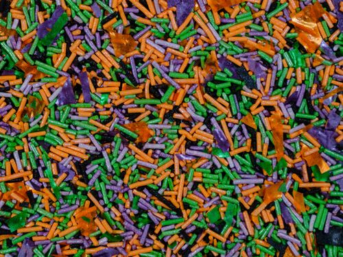 Free Vibrant close-up of Halloween-themed sprinkles in green, orange, and purple hues. Stock Photo