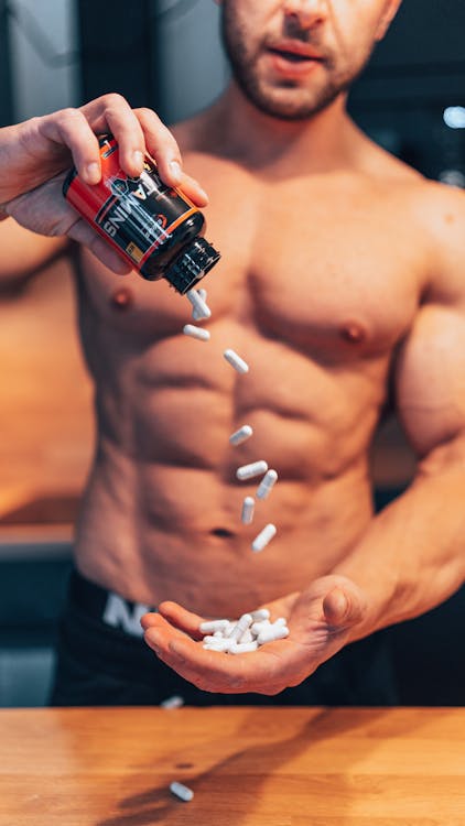 Free Shirtless Man Throwing Pills Out of a Bottle Stock Photo