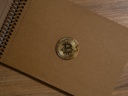 Close-up Photo of Gold Bitcoin on a Notebook 