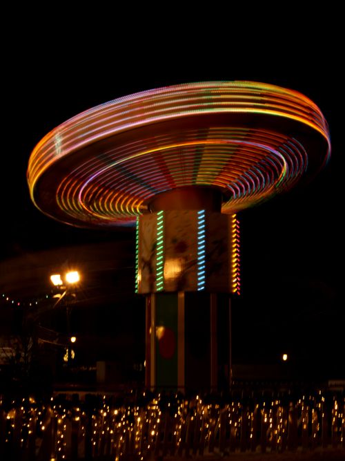 Free Colorful motion blur of a spinning carnival ride illuminated against the night sky. Stock Photo