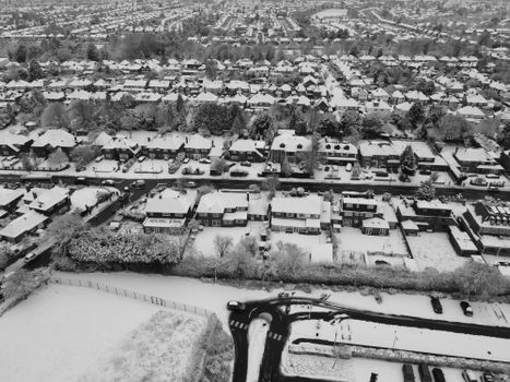 A breathtaking aerial view of a snow-covered residential area in Luton, England during winter.