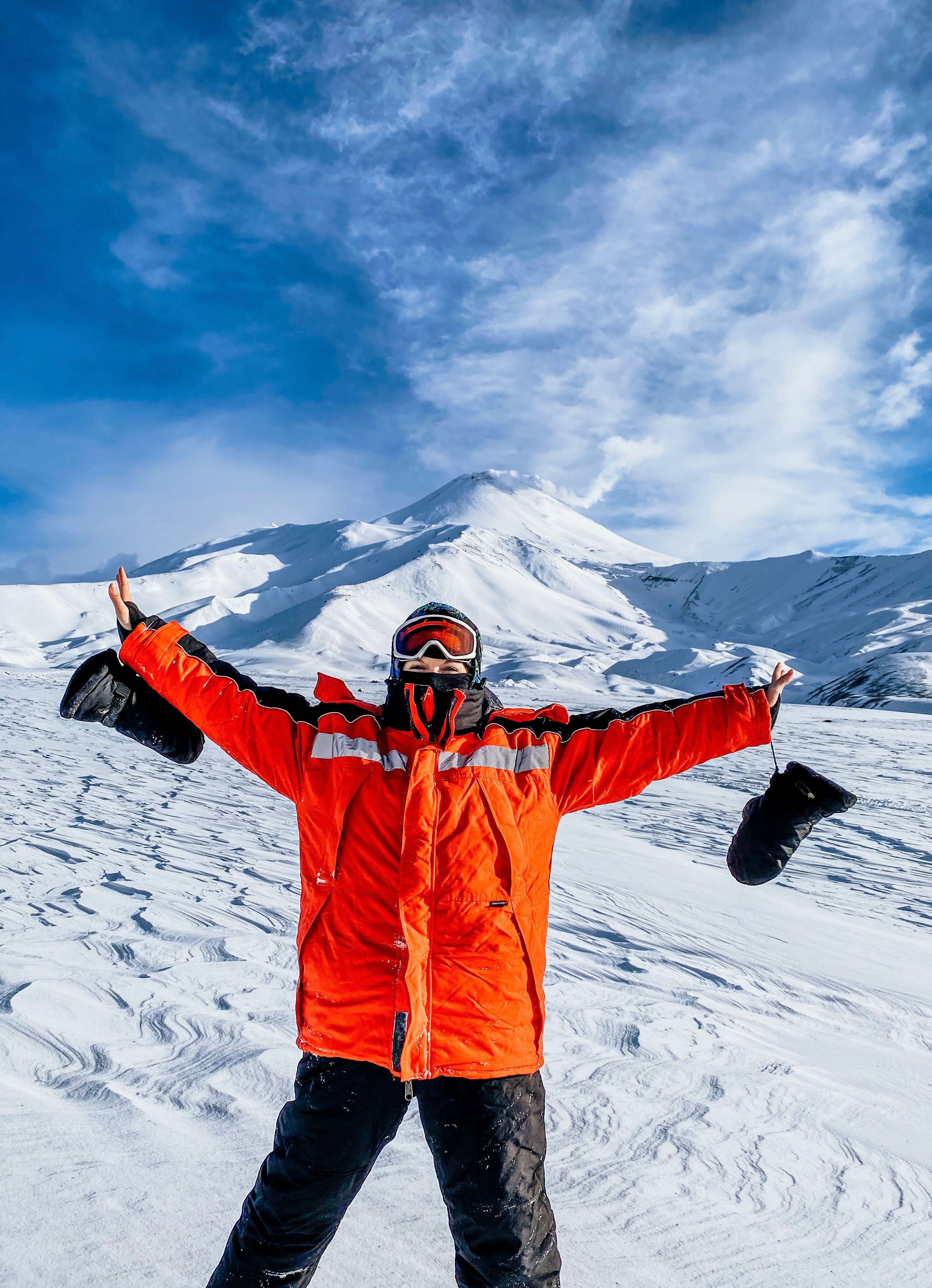 Man Wearing Orange Jacket in a Mountain Valley · Free Stock Photo