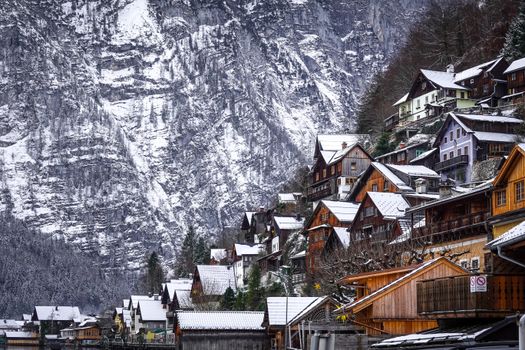 Picturesque snowy village of Hallstatt, Austria with traditional alpine architecture and snowy landscape.