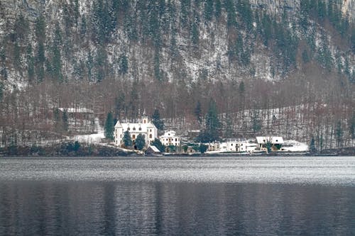 Houses at Mountain Foot near Lake in Winter