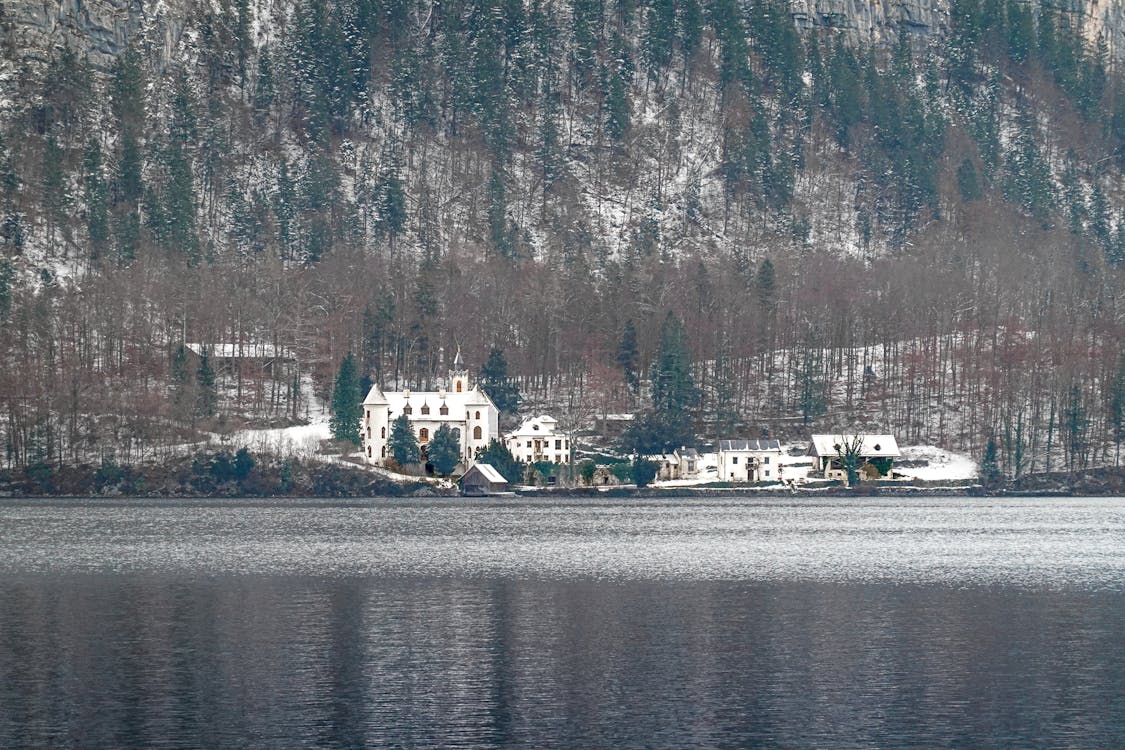 Houses at Mountain Foot near Lake in Winter