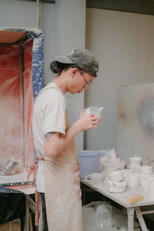 A potter examining a finished ceramic cup in the studio — photo by Pew Nguyen on Pexels