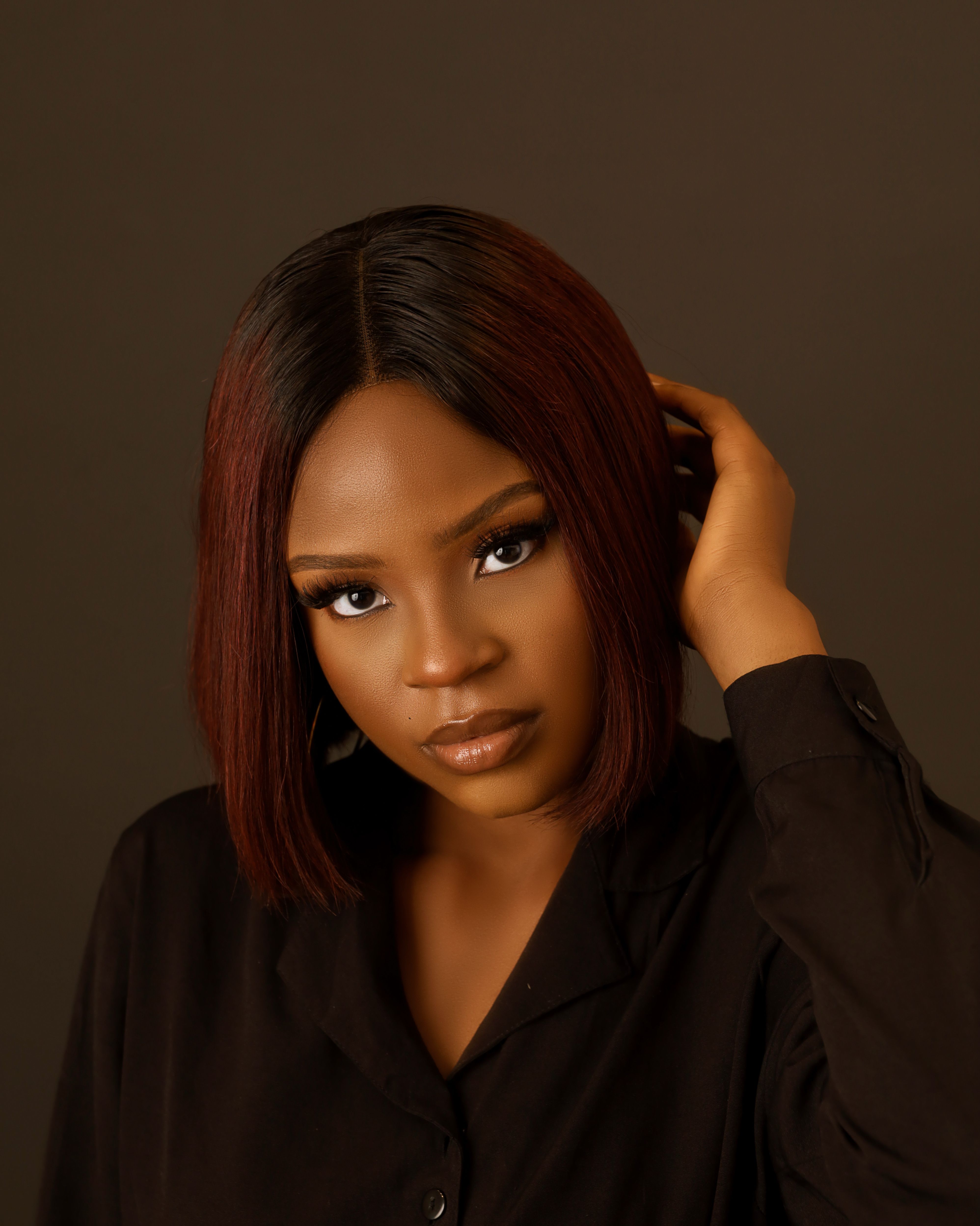 Striking studio portrait of a young woman exuding confidence and elegance.