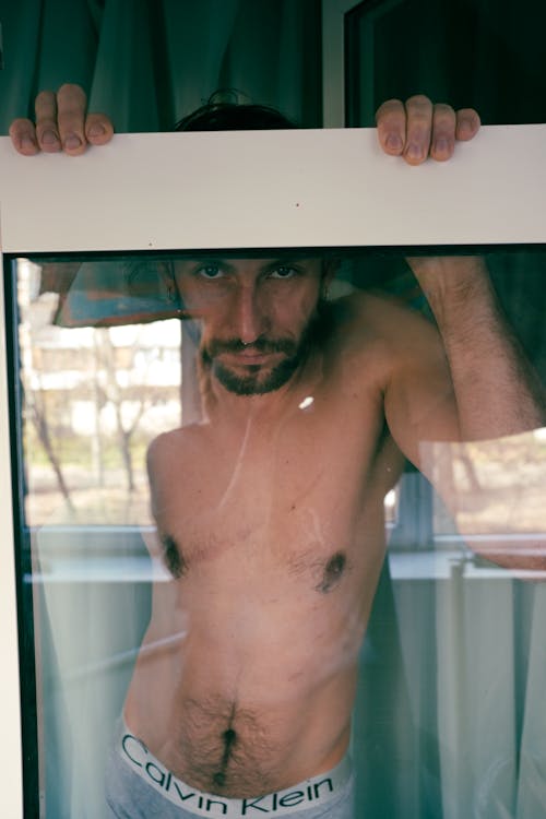 Topless Man behind Window