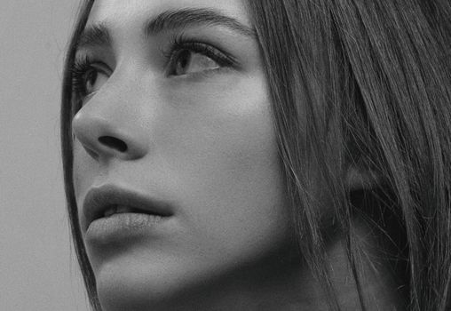 Close-up black and white portrait capturing a woman's timeless elegance and expression.