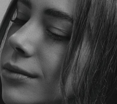 Elegant black and white close-up portrait of a woman with eyes closed, highlighting serene expression.