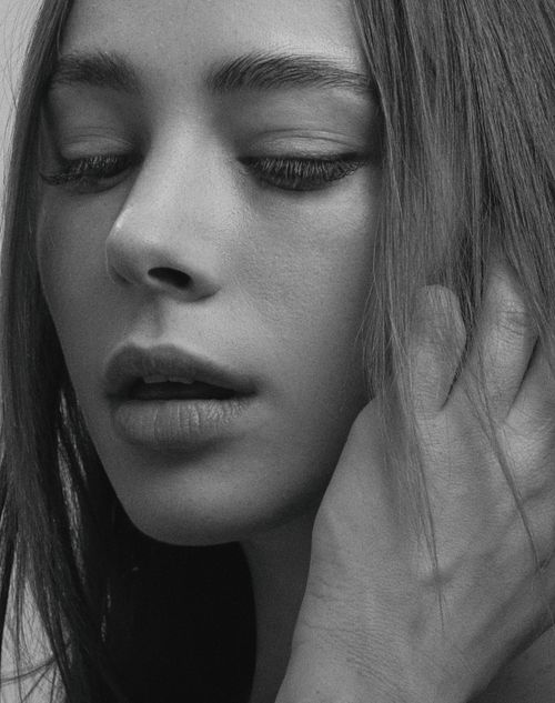 Free Artistic black-and-white portrait of a woman with a serene expression and soft lighting. Stock Photo