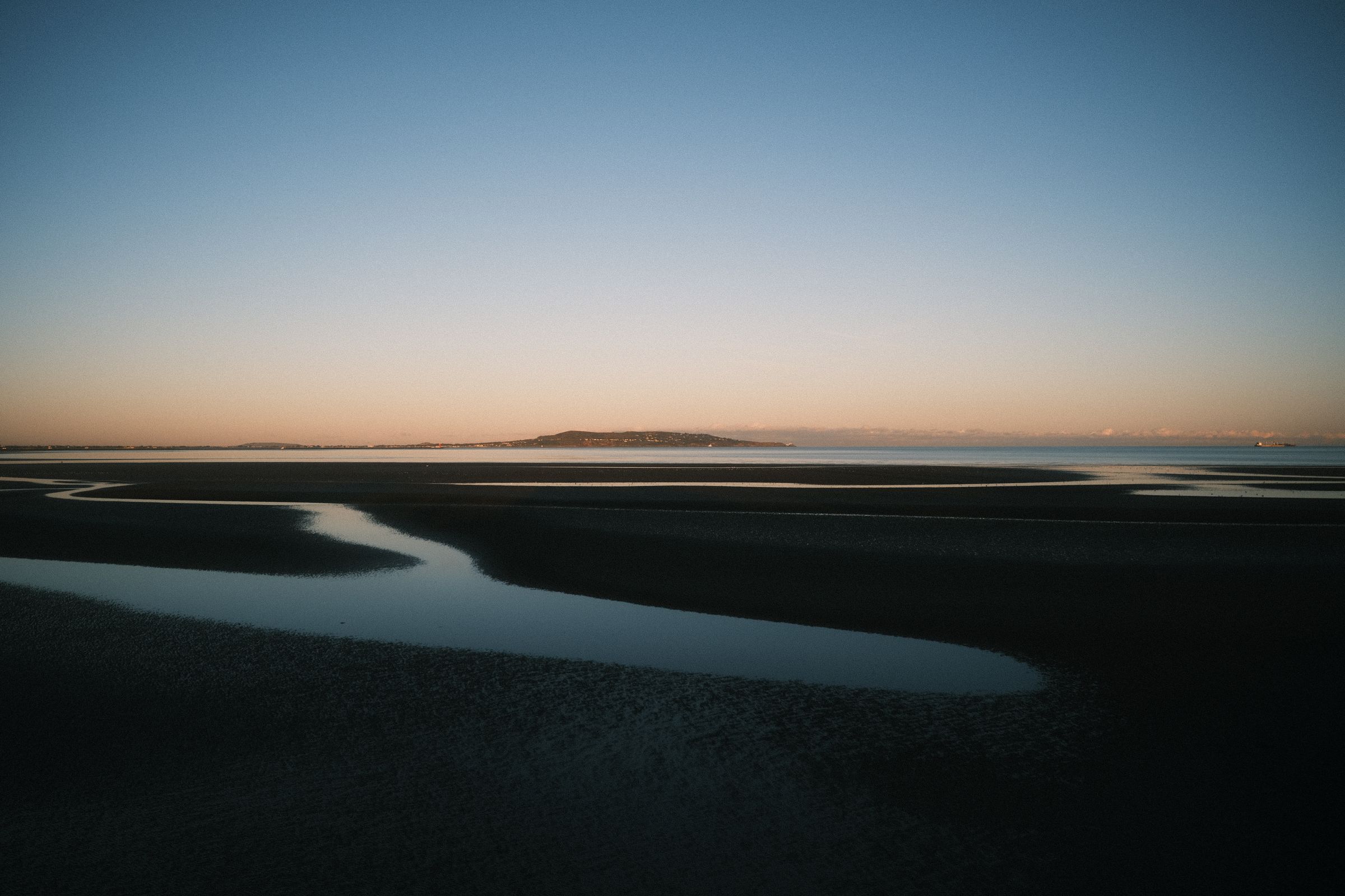 Evening view of Dublin's coastline with soft lighting and calm waters
