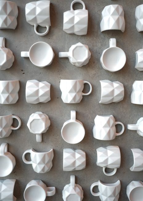 White geometric cups arranged on gray surface, shot in Tokyo.