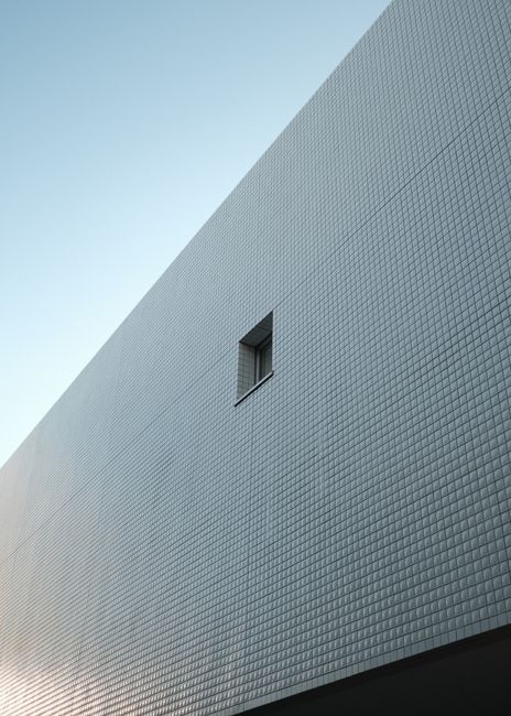 Modern minimalist building facade with a single window in Shibuya, Tokyo.