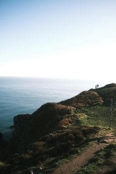 Captivating view of Dublin's coastal cliffs with hikers enjoying the serene ocean scenery.