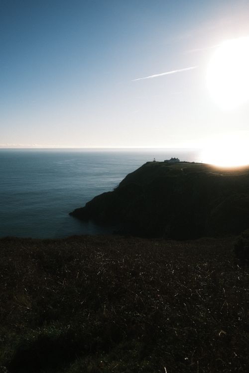 Free Capture of the stunning sunset over Howth Head, showcasing Dublin's rugged coastline under the soft evening light. Stock Photo