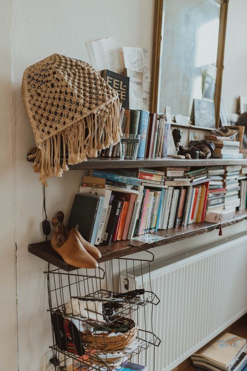 Free Warm and inviting living space featuring a bookshelf with books, decor, and vintage elements. Stock Photo